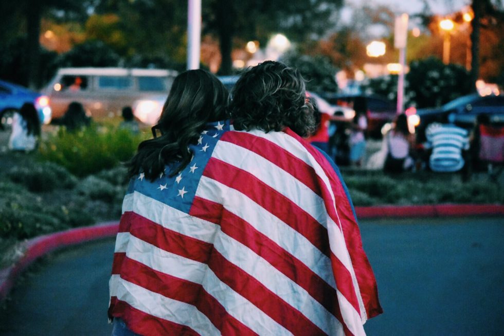 Two people wrapped in an American flag